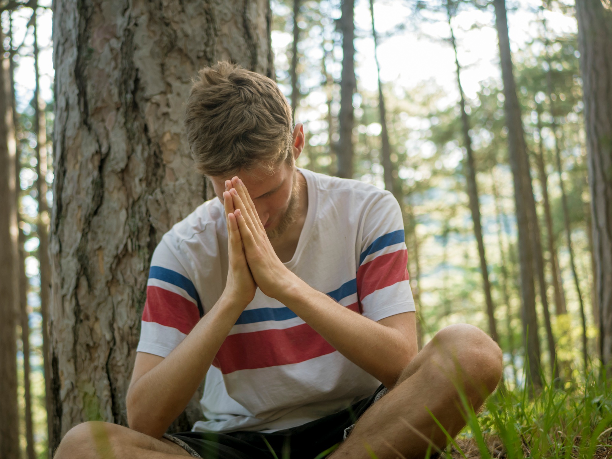 close up portrait of man doing yoga and spiritual activity in the nature forest